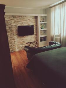 een slaapkamer met een bakstenen muur en een flatscreen-tv bij B&B San Paolo Sweethome in Parma