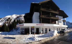 a large building in front of a snow covered mountain at Hotel Berghof in Sonnenalpe Nassfeld