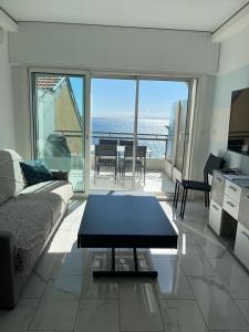 een woonkamer met een bank en een tafel bij Le Grand Bleu in Nice