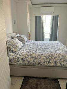 een slaapkamer met een bed met een blauw en wit dekbed bij Le Grand Bleu in Nice