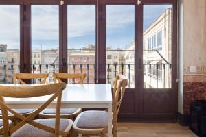 a table and chairs in a room with a balcony at Central Apartments Barcelona in Barcelona