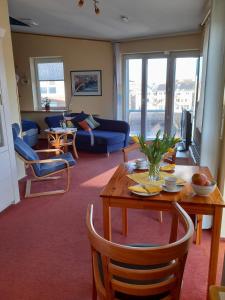 ein Wohnzimmer mit einem Tisch und einem Sofa in der Unterkunft Hafenblick-City Apartment Husum in Husum