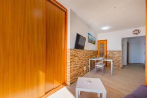 a living room with a wooden door and a table at Spacious studio next to the sea with stunning views in Santa Cruz de Tenerife +11 photos