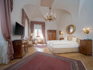 a large bedroom with a bed and a tv in it at Hotel Schloss Dürnstein in Dürnstein