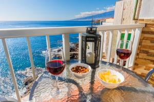 a table with two glasses of wine on a balcony at Spacious studio next to the sea with stunning views in Santa Cruz de Tenerife