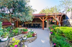 a patio with a bunch of plants and flowers at Gonar 300 Rab in Supetarska Draga