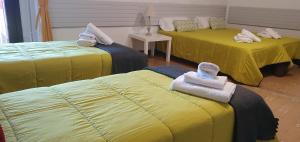 - une chambre avec 3 lits et des serviettes dans l'établissement espai Abadia, à Argentera