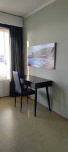 una mesa y una silla en una habitación con una pintura en Villa Astrid en Pietarsaari