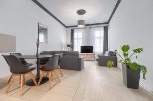 uma sala de estar com mesa e cadeiras em Aparthotel Platinum em Szczecin