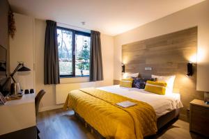 a hotel room with a large bed and a window at Boutique Hotel Bed&Bos in Best