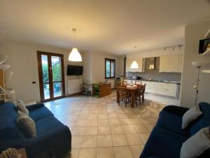 a living room with a blue couch and a kitchen at SUITE TRAVEL HOME in Modena