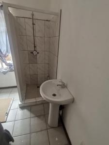 a bathroom with a white sink and a shower at Sunset Executive Lodge in Boksburg +51 photos