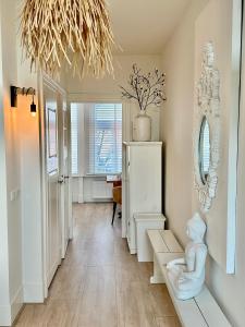 a hallway with a room with a mirror and a statue at Oranje Nassau aan Zee Appartement in Zandvoort