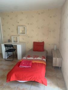 a small room with a bed and a desk at Logement dans maison en pierre à la campagne in Bazens