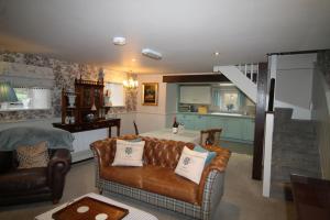 a living room with a couch and a kitchen at Mr Ralphs Cottage in Whitby