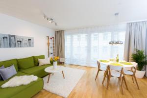 sala de estar con sofá verde y mesa en Rafael Kaiser - Aurea Apartment - Contactless 24h Check-In -, en Viena