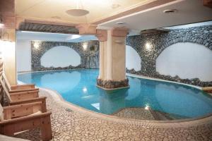 a large swimming pool in a hotel room with a spa at Hotel Helvetia in Livigno