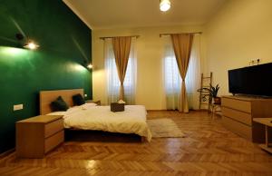 Branko's Residence في تيميشوارا: غرفة نوم خضراء مع سرير وتلفزيون بشاشة مسطحة