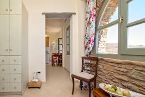 a living room with a table and chairs and a window at m.houses 2 in Agios Romanos