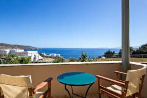 stół i krzesła na balkonie z widokiem na ocean w obiekcie m.houses 2 w mieście Agios Romanos