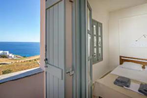 a room with a bed and a view of the ocean at m.houses 2 in Agios Romanos
