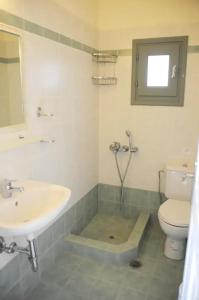 a bathroom with a sink and a toilet and a mirror at m.houses 2 in Agios Romanos