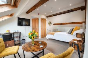a bedroom with a bed and a table with flowers on it at Luxury Studio Apartment - Town Centre in Whitehaven