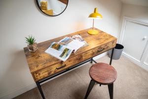 a wooden desk with a lamp and a chair at Luxury Studio Apartment - Town Centre in Whitehaven