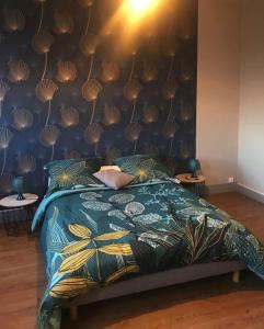 a bedroom with a bed with a blue comforter at Gîte spacieux et chaleureux in Sainte-Mère-Église