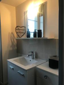 a bathroom with a sink and a mirror at Gîte spacieux et chaleureux in Sainte-Mère-Église