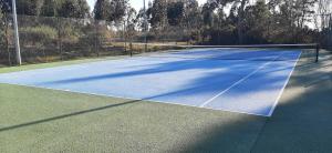 a tennis court with a net on top of it at O MEU LAR in Roxos