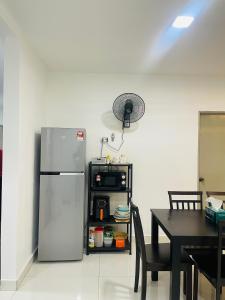 a kitchen with a stainless steel refrigerator and a table at SSHomestay in Skudai