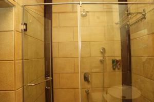 a bathroom with a shower with a glass door at The Stoneberry Resort in Madhupur