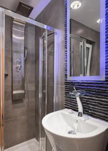 a bathroom with a sink and a shower at Mirada Hotel in Athens