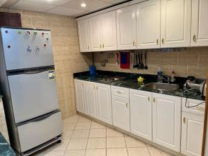 a kitchen with white cabinets and a refrigerator at Nabq Bay Amwaj Oyoun Hotel in Sharm El Sheikh