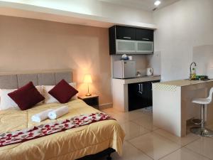 a hotel room with a bed and a kitchen at The Viana Apartment 1 in Kota Bharu
