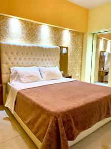- une chambre avec un grand lit et une grande tête de lit dans l'établissement Pilo Lala Hotel, à Lushnjë