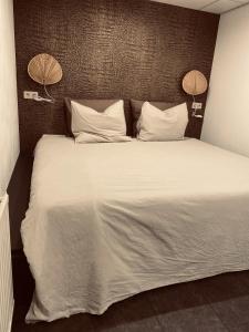 um quarto com uma cama grande com lençóis brancos e 2 candeeiros em By Balu em Soest