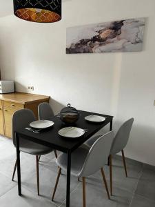 einem Esstisch mit Stühlen und einem schwarzen Tisch in der Unterkunft Ferienwohnung Makar in Burladingen
