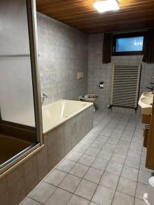 a bathroom with a tub and a toilet at Ferienwohnung Makar in Burladingen