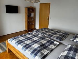 ein Bett mit einer Decke auf dem Zimmer in der Unterkunft Ferienwohnung Makar in Burladingen