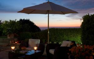 a patio with an umbrella and chairs and a table at B&B Il Tramonto in Anacapri +25 photos