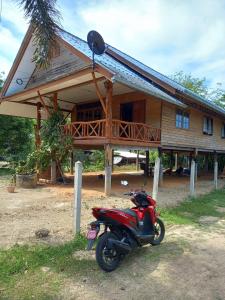 a red motorcycle parked in front of a house at Artist Homestay in Ko Yao Noi