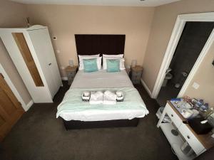 1 dormitorio con 1 cama grande con almohadas azules en Highfield Coach House en Lymington