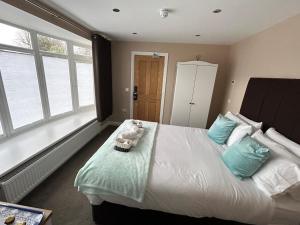 a bedroom with a large white bed with blue pillows at Highfield Coach House in Lymington
