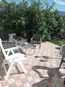 a patio with white chairs and a table and chairs at Lovely 1-Bed Apartment in Gallinaro in Gallinaro
