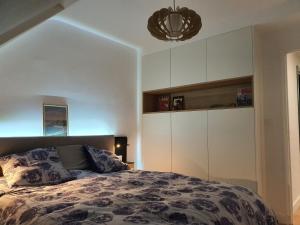 een slaapkamer met een bed en een grote witte kast bij Appartement Bretagne vue mer exceptionnelle sur les hauts d'Erquy au calme ! et au pied du GR34 in Erquy