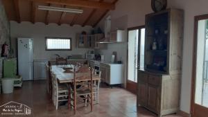 cocina con mesa de madera y comedor en Casa Rural Mas de les Àligues en Mequinenza