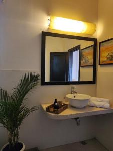 baño con lavabo y espejo en la pared en Villa Papillon en Phnom Penh