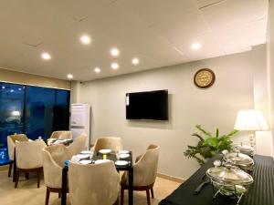 einen Konferenzraum mit einem Tisch, Stühlen und einer Uhr in der Unterkunft Grand Luxury Hotel Multan in Multan